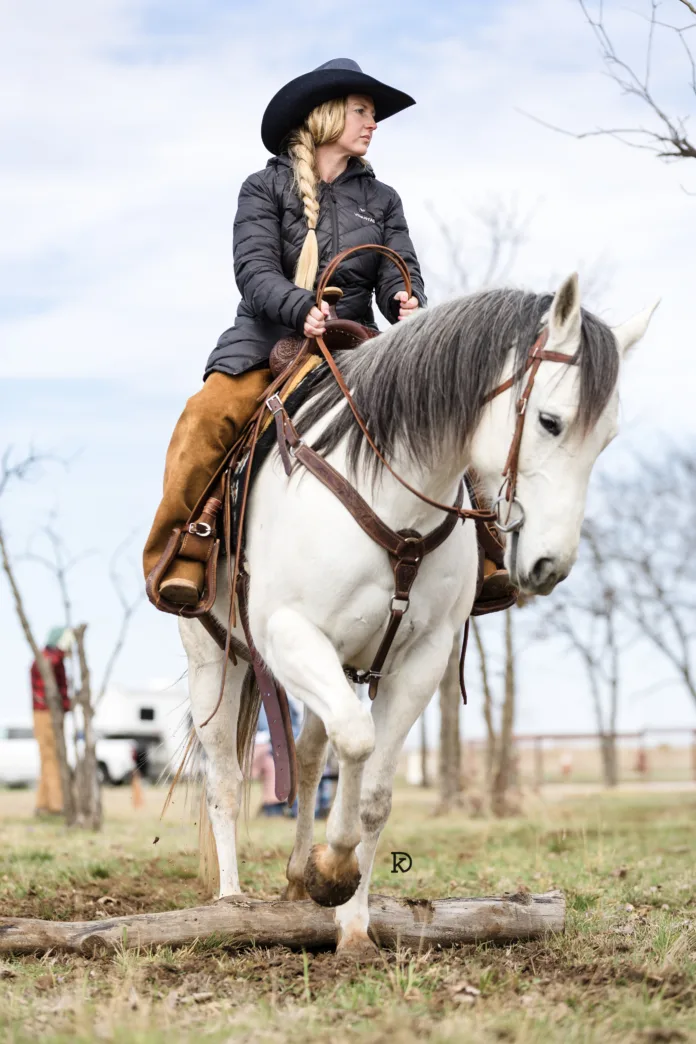 A rider works a horse over a log at Cross Brand Cowboy Church.