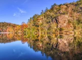 Trails Worth Taking An Oklahoma lake framed by autumn timber and a rocky bluff.