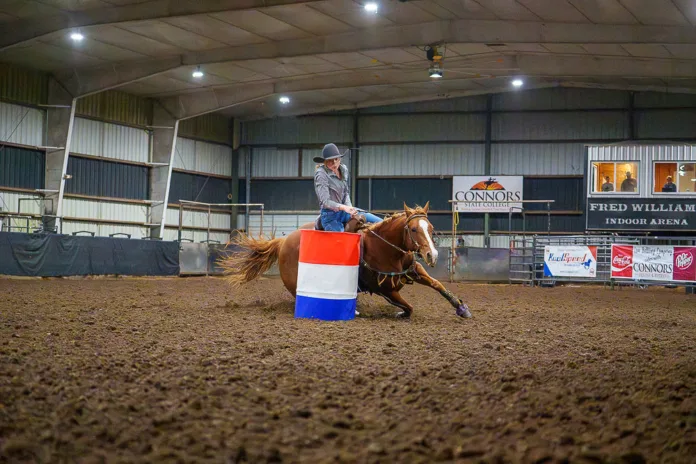 CSCBarrelRacing-2 A barrel racer rounds a barrel in the Fred Williams Arena at Connors State College.
