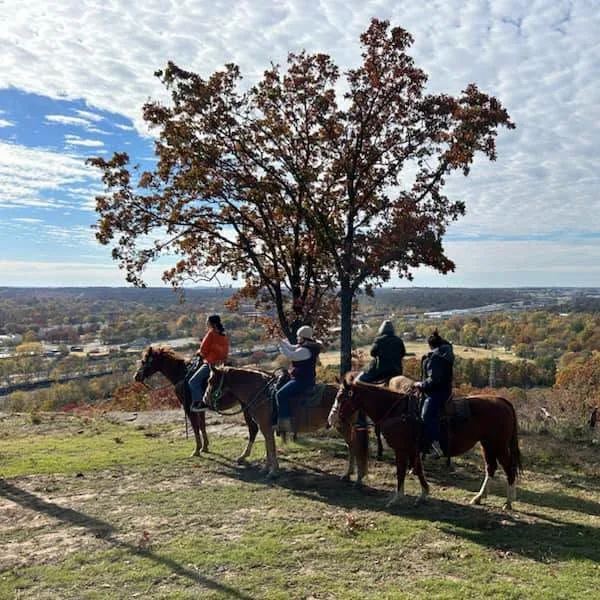 Riders pause under an autumn oak on a Tulsa Trails West ride.